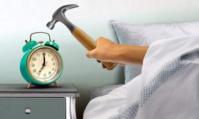 hand hitting alarm clock with hammer; Shutterstock ID 486440014