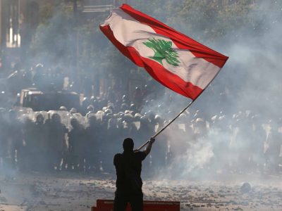 A demonstrator waves the Lebanese flag in front of riot police during a protest in Beirut, Lebanon, August 8, 2020. REUTERS/Goran Tomasevic     TPX IMAGES OF THE DAY