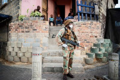 A South African National Defence Force (SANDF) soldier stands in front a house as he patrols the streets in Alexandra, Johannesburg, on March 27, 2020 during a joint operation with the South African Police Service (SAPS) in order prevent the spread of the COVID-19 coronavirus outbreak. - South Africa came under a nationwide lockdown on March 27, 2020, joining other African countries imposing strict curfews and shutdowns in an attempt to halt the spread of the COVID-19 coronavirus across the continent. (Photo by Luca Sola / AFP) (Photo by LUCA SOLA/AFP via Getty Images)