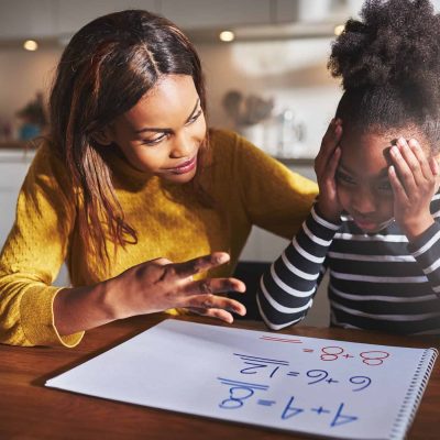 Mother learning her daughter to calculate elementary school work